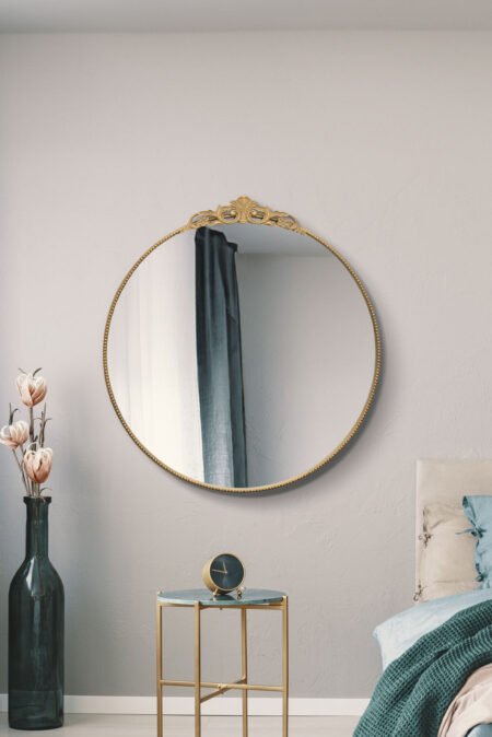 Round gold ornate mirror with beaded frame and decorative crown