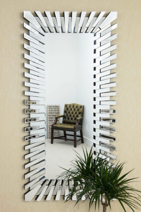 Full length rectangular wall mirror with staggered bevelled glass brick frame displayed in a living room