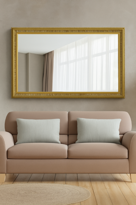 Large decorative wall mirror with ornate gold frame hung above a taupe sofa